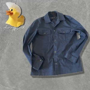 Mörkblå trenchcoat overshirt - Säljer denna marinblåa overshirt från Mango. Storlek XS, men sitter som S. Passar folk runt 172-183cm. Overshirten har liknande material som trenchcoats vilket gör den ännu snyggare. Kontakta om du har frågor