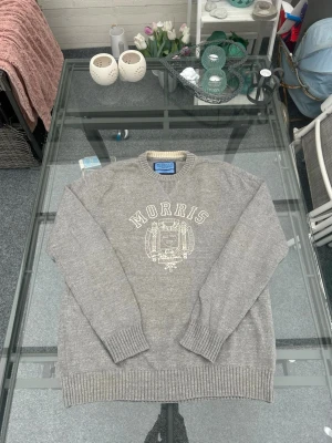 Morris knit crewneck old money L - Morris Co knit i size L i clean gråmelerad färg. 100% bomull och riktigt skön quality. Broderat Morris-logo/crest framtill som ger en preppy, old money och vintage vibe. Perfekt till skjorta under, jeans, chinos eller loafers. Fint skick och sitter clean för både casual och dressade fits ✨📦