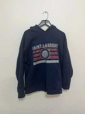 Saint Laurent hoodie - Marin blå hoodie från Saint Laurent | strlk M | Mycket bra skick saknar däremot snörena | hör av er vid fundering!