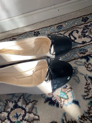 Svartvita ballerinaskor med rosett - Själv har jag storlek 39 men de är väldigt små i storleken , de passar någon med storlek 38 ;)  aldrig använd 