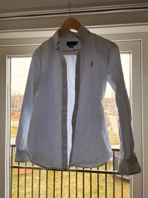 Randig skjorta från Ralph Lauren - Säljer nu min skjorta från Ralph Lauren. Passar sjukt bra nu till sommaren! Skicket är bra knappt använd, max 2 gånger! Hör av dig vid frågor!😃🤩