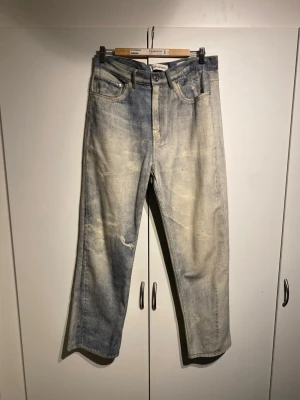 Ljusblå raka jeans från Our Legacy - Säljer ett par ljusblå raka jeans från Our Legacy med slitna detaljer och tvättad look. Jeansen har klassisk femficksdesign, knappgylf och är tillverkade i bomull. Perfekta för en avslappnad och trendig stil. Nypris närmare 5000kr. Storlek 31 och True to size.