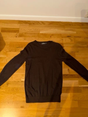 Svart tröja från Dressmann - En stilren svart tröja från Dressmann i mjuk supima bomull. Tröjan har rund halsringning, långa ärmar och ribbade muddar vid ärmslut och nederkant. Perfekt för dig som gillar en enkel och klassisk look.