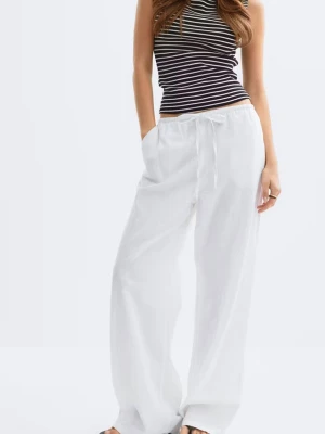 Gina tricot young Vita  linnebyxor med dragsko 158 /164 - Säljer ett par vita linnebyxor med avslappnad passform och dragsko i midjan. Byxorna har raka, vida ben och sidofickor. Perfekta för en chill och stilren look. Stl 158/164