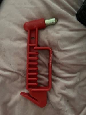 Röd portabel dörrlåsare i plast - En röd portabel dörrlåsare i robust plast med metallspets. Perfekt för att snabbt och enkelt låsa dörrar inifrån utan verktyg. Smidig att ta med på resor eller använda hemma för extra säkerhet.