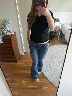 INTRESSEKOLL! Mörkblå bootcut jeans true religion - Snygga mörkblå bootcut jeans med klassisk femficksdesign och dragkedjegylf. Jeansen har en lätt tvättad look och raka ben som går ut lite nedtill. Perfekta till sneakers eller boots för en avslappnad stil. Slitningar vid benslut (se bild)