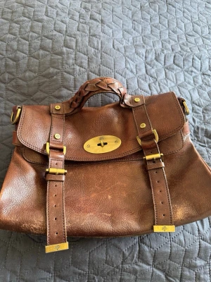 Brun läder väska - M Alexa. Väldigt fin och med en härlig vintagekänsla. Den har vissa bruksspår, men eftersom den är i läder går den att vårda och fräscha upp. Ingen axelrem.