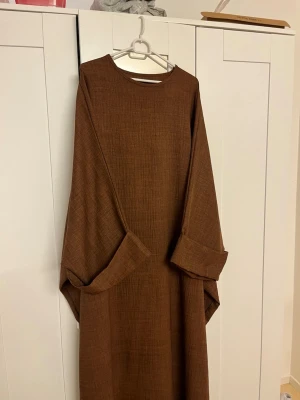 Brun abaya  - Butterfly abaya i mjukt linen material, i strl XL. Använd och slitaget syns på bilderna.