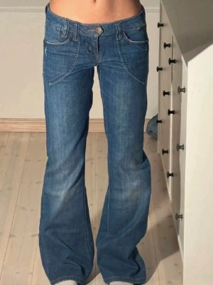 Blå bootcut jeans med låg midja - Säljer ett par blå bootcut jeans med låg midja och snygga sömdetaljer framtill. De säljs då jag inte använder de så mycket🥰