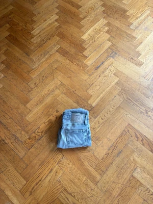 Ljusblå slim fit jeans - Säljer ett par ljusblå slim fit jeans med klassisk femficksdesign och dragkedjegylf. Jeansen har en modern, smal passform och är tillverkade i ett mjukt denimtyg med lite stretch för extra komfort. Måten är W28 och längd 30