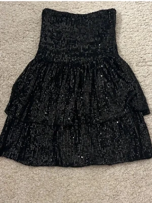 Svart paljettklänning med volanger - Glitter klänning 146/150, jag använder S i vanliga fall (är 165) och den är lite tajt på mig! Från Gina, aldrig använt den!