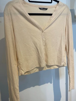 Beige kofta - En beige kofta/tröja med en knapp från Shein, storlek XS.