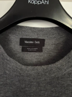 Grå cashmere-tröja Massimo Dutti - Snygg och enkel grå stickad tröja från Massimo Dutti i 100% cashmere. Tröjan har rund halsringning och perfekt för dig som gillar stilrena och mjuka plagg. Passar till det mesta och är superbekväm. Är dessutom ganska tunn så passar perfekt till sommaren.  Storlek L men sitter mer som M