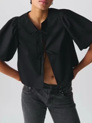 Svart blus med puffärm och knyt - Använd endast 1 gång så verkligen i helt nyskick. Trendig svart och beige blus med stora puffärmar och två knyt framtill. Croppad modell med öppen front och rund halsringning. Tillverkad i ett slätt tyg som ger en stilren look. nypris: 499 styck. Mitt pris 50 kr styck eller båda för 80 kr