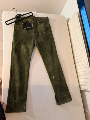 Dsquared Jeans - Snygga olivgröna jeans från Mos Mosh med rak passform och diskreta stänk av glitter över hela byxan. Klassisk femficksmodell med knapp och dragkedja. Tillverkade i ett mjukt bomullsmaterial med stretch för extra komfort.