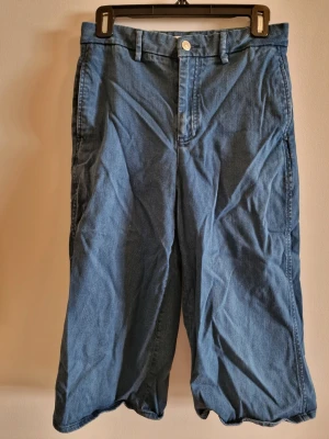 Vida jeans från Zara Woman - Snygga blå jeans från Zara Woman Premium Denim Collection. Modellen är vid med raka ben och klassisk femficksdesign. Tillverkade i denim med knapp och dragkedja framtill samt hällor för skärp. Trekvartslängd