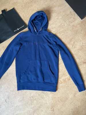  Sail Racing Hoodie i nyskick + Exklusiv Påse! 💎 - ✨ Detaljer: • Märke: Sail Racing • Storlek: XS (Passform: Slim fit / Sitter tajt och snyggt) • Färg: Marinblå • Skick: Mycket gott skick, väl omhändertagen. • Bonus: Original Sail Racing tygpåse medföljer vid köpet! 🛍️  • Höjd: 63 cm • Bredd: 43 cm  🚀 Snabb frakt: Jag skickar alltid inom 24 timmar!