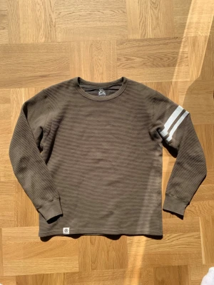 Momotaro GTB Longsleeve - Longsleeve från Momotaro med de ikoniska GTB sträcken på armen. Olivgrön färg med unikt mönster samt en Momotaro logga längst ner. Storlek M men utgå från måtten:  Längd (ryggrad): 62 Bredd (över bröstet): 50 Armlängd: 59  Skriv vid frågor eller funderingar! /william