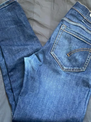 Mörkblå jeans med tvätt från dondup - Snygga mörkblå slim jeans med  kontrastsömmar. Jeansen har en smal passform och är tillverkade i stretchigt denimtyg för extra komfort. Perfekta för dig som gillar en stilren och enkel look.