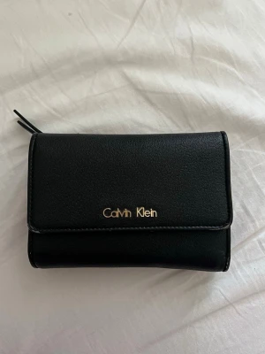 Plånbok  - En snygg dam plånbok från Calvin Klein, den har lite skador men är nästan osynliga. 