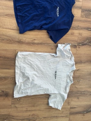 Jack & Jones Originals t-shirt X-Small - Två stilrena t-shirts från Jack & Jones Originals i storlek X-Small. En är marinblå och den andra vit, båda med diskret logga på bröstet. Klassisk passform och korta ärmar, perfekta till jeans eller shorts. Tillverkade i mjuk bomull för skön känsla.