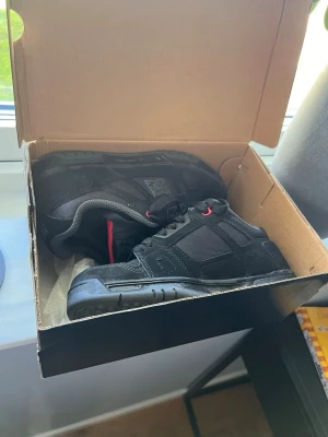 Svarta DC sneakers med röda detaljer - Hej säljer dom här dc skorna som är perfekta. Inte det minsta utslitna och bara använd i någon dag! (Seriösa köpare bara)  Pris är inte orginalt och går inte ned på det!   Mvh Douglas    Kan skickas 