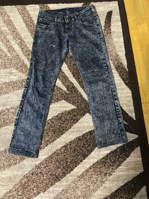 Acid wash raka jeans blå - Säljer ett par blå acid wash jeans med raka ben och klassisk femficksmodell. Jeansen har en cool tvättad look och normal midja. Perfekta för dig som gillar retrostil och vill sticka ut lite extra. Materialet är denim i bomull. Kan gå ner i priset 