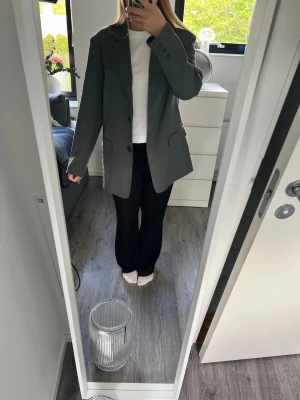 Grå blazer - Snygg grå blazer från Nelly med klassisk passform och två knappar framtill. Aldrig använd men klippt av lapparna.