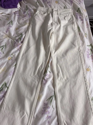 Vida vita jeans från Gina Tricot - Snygga vita jeans från H&M med raka, vida ben och hög midja. Jeansen är tillverkade i 100% bomull och har klassisk femficksdesign samt dragkedjegylf. Perfekta för en clean och fräsch look.