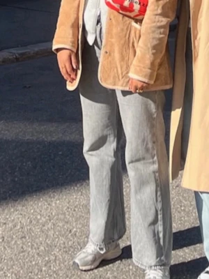 Grå raka jeans med hög midja - Säljer ett par grå jeans med rak passform och hög midja. Jeansen har klassiska fem fickor och är tillverkade i denim. Perfekta för en avslappnad/oversize och trendig look. Storlek 44, men passar en M/L.