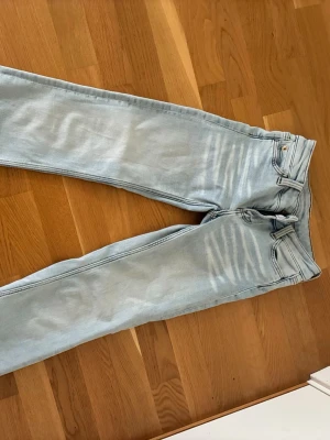 Ljusblå Bootcut  jeans med guldknapp - Snygga jeans från weekday i storlek 25/32. Jag e 162 och de passar perfekt!💕