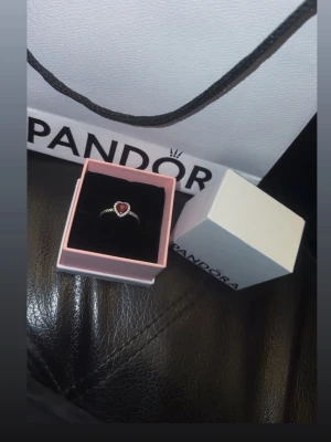 Pandora silverring med röd hjärtformad sten ❤️ strl 52 - Säljer min superfina silverring från Pandora, den är helt oanvänd. Den har röd hjärtformad sten i mitten och små stenar längs bandet. Den är i storlek 52 och allt man får till syns på första bilden. Ny pris 799kr. Priset kan diskuteras 🩷hör av er vid eventuella frågor/bilder