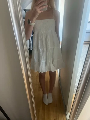 Vit kort klänning  - Superfin vit kort klänning med smala axelband och smock upptill. Klänningen är från gina tricot och är i princip oanvänd. 