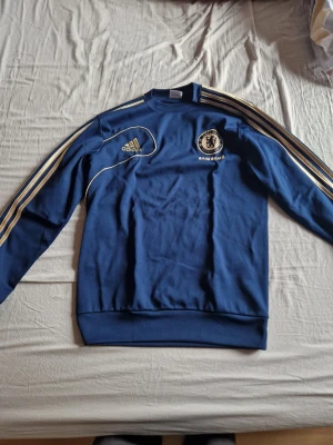 Chelsea fc sweatshirt adidas - Mycket fin och sällsynt chelsea tröja. Tröjan har ett litet hål på vänster ärm men utöver det, jättefint skick.