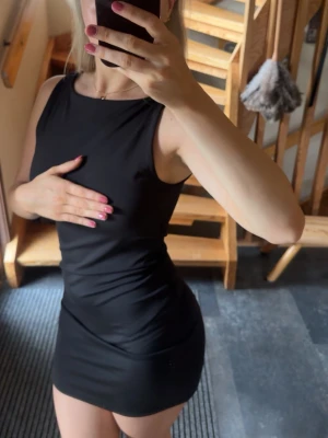 Svart ärmlös kortklänning - Svart kortklänning med ärmlös design och rak hals. Klänningen har en tight passform och är i stretchigt material som formar dig efter kroppen. Det är extra tyg vid bysten så man kan ha på sig klänningen utan bh! Endast använd 1 gång och är i toppenskick!🌸 Köpt på stradivarius i Lissabon, storlek S 🌸