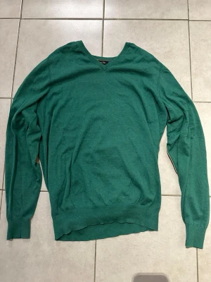 Grön stickad tröja Massimo Dutti - Snygg grön stickad tröja från Massimo Dutti med V-ringning. Perfekt för dig som gillar stilrena och bekväma plagg. 