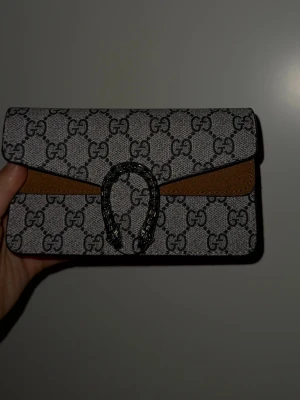 Gucci väska  - Gucci väska, fejk, använd 2 tillfällen, axelband i väskan, jätte fin till sommaren. 