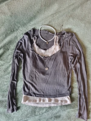 Grå coquette långärmad topp - Tunn ribbad topp med spets/rosett detaljer, passar till layering. Använd fåtal gånger utan defekter. 
