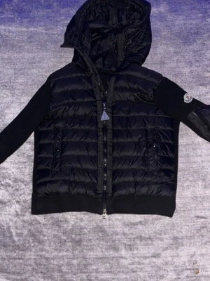 Nfc funkar. Svart pufferjacka från Moncler storlek m passar i s också - Nfc funkar. Säljer en svart pufferjacka från Moncler med quiltad front och rygg, stickade ärmar och huva. Jackan har dragkedja med Moncler-logga och två fickor med knappar. Perfekt för kalla vinterdagar och snygg att matcha med jeans. Storlek m passar i s också 