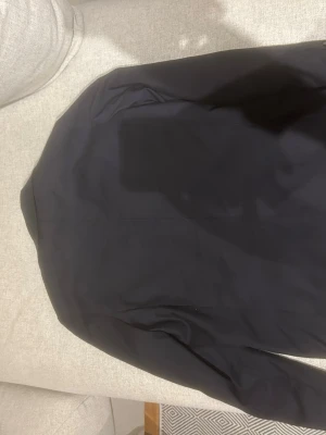 Mörkblå klassisk kavaj - Stilren mörkblå kavaj med enkelknäppning och smal passform. Kavajen har långa ärmar, klassisk krage och en ficka framtill. Perfekt för en dressad look och funkar till många olika outfits.