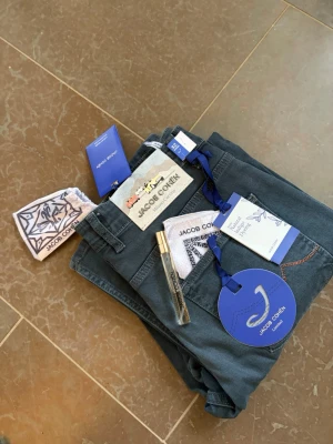 Mörkblå jeans från Jacob Cohën - Snygga mörkblå jeans från Jacob Cohën Limited med klassisk femficksmodell och detaljer som kontrastsömmar och exklusiv etikett bak. Jeansen har en medelhög midja och raka ben. Tillverkade i mjukt denimtyg och levereras med en färgglad näsduk i fickan. Pris diskuterbart 😉