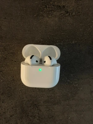Apple AirPods 4 - Säljer ett par vita Apple AirPods 4. Hörlurarna har en stilren och kompakt design i blank plast och sitter bekvämt i öronen. Perfekta för musik, samtal och träning. Orginalförpackningen medföljer!
