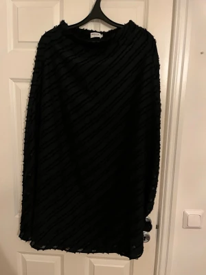 Svart mönstrad klänning MSCH XS - Säljer en svart kjol från MSCH Copenhagen i storlek XS. Den har ett diskret diagonalt mönster och en lös passform. Perfekt för dig som gillar stilrena plagg med en twist.