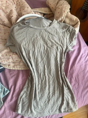 Beige t-shirt från 157 - En enkel och stilren beige t-shirt från 157 i storlek XS. T-shirten har rund halsringning och korta ärmar. Tillverkad i mjuk bomull som känns skön mot huden. Perfekt basplagg att matcha med allt i garderoben.