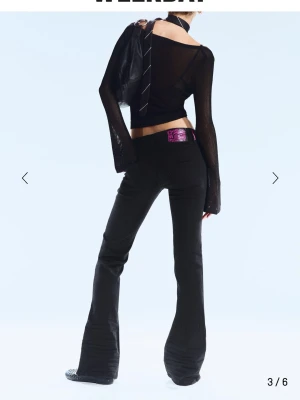 Svarta bootcut jeans från Cheap Monday - Säljer ett par svarta bootcut jeans från Cheap Monday med lila logga på bakfickan. Jeansen har hög midja, klassiska fem fickor och är tillverkade i stretchigt denimtyg för en bekväm passform. Perfekta för en edgy och trendig look.