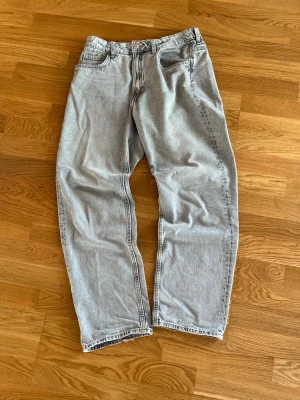 Grå loose fit jeans från H&M - Säljer ett par grå loose fit jeans från H&M med justerbar midja och raka ben. Jeansen har klassisk femficksdesign och är tillverkade i bomull. Perfekt för dig som gillar en avslappnad och trendig look. Byxorna är i storlek 170/S. Skriv om du undrar något så löser vi det!