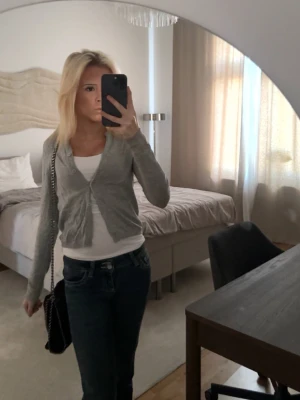 Grå kofta från 157, XS - Säljer en tunn, ljusgrå kofta från 157 i storlek XS. Koftan har långa ärmar och knyts framtill, perfekt att slänga över ett linne eller t-shirt. Enkel och stilren design som passar till jeans. Har använt ett par gånger men inga hål eller fläckar!!