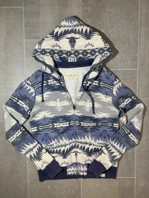 RLDS Aztec Zip-Up Hoodie - Snygg zip up från Ralph Lauren Denim & Supply i deras Aztec kollektion.                                                                                   Längd (dragkejdan) 56 Bredd (över bröstet) 55 Ärmlängd (från axeln) 69 
