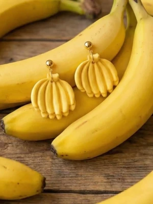 Handgjorda örhängen i Polymerclay "Bananklase" - Ca 3 x 2 cm. Handgjorda örhängen i Polymerclay. Härdade i ugn. Alla smyckesdelar är i äkta silver,  guldpläterat eller rostfritt stål. Ett lätt material som inte tynger ner öronen. Allergivänligt ❤️ (De som har glitter är förseglade med lack för Polymerclay,  så inget faller av.) 
