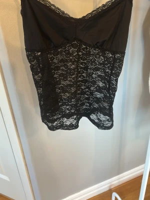 Svart spets linne från brandy mellvile  - Snyggt svart spets linne med tunna axelband och v-ringning. Överdelen är i slätt tyg medan resten är i  spets. Linnet är från brandy mellville.  Använd ensta 2 gånger 